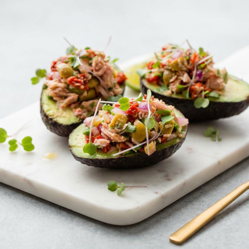 Creamy avocado tuna salad boats, generously filled into avocado halves and garnished with fresh herbs.
