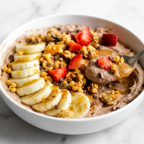 Fluffy protein yogurt bowl with whipped mousse texture, topped with fresh berries, granola, and chia seeds.