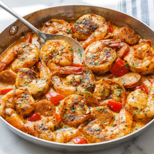 A rich, creamy spicy keto shrimp and sausage skillet with bright bell peppers, green onions, and tender shrimp in a thick, reddish sauce.