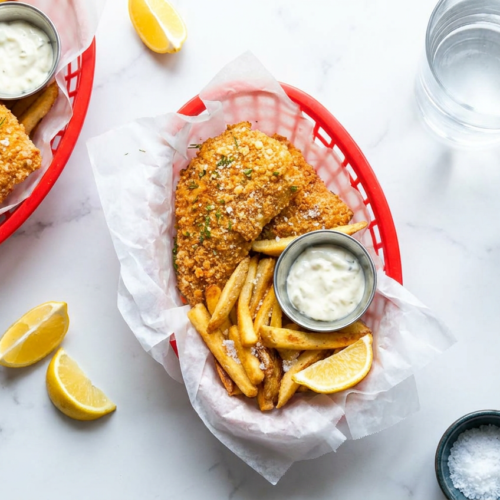 Platter of crispy, golden high protein air fryer fish and chips served with lemon wedges and fresh dill.